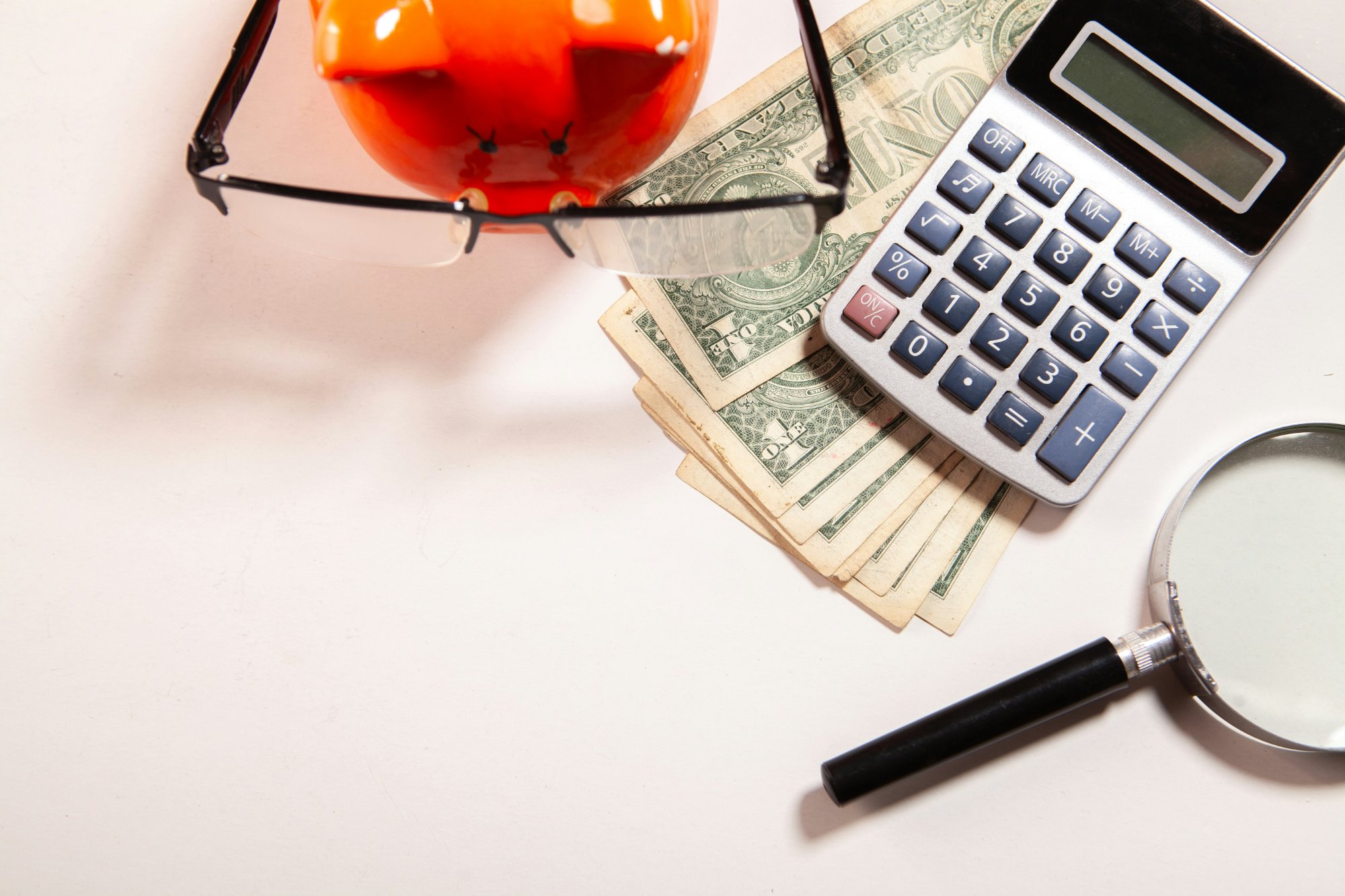 Calculator, cash and piggy bank — estimating Eagle Loan monthly payments